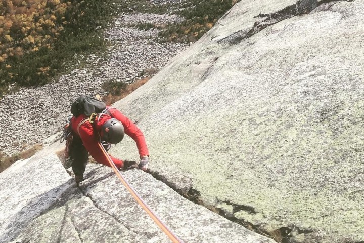 a person climbing up a rocky cliff