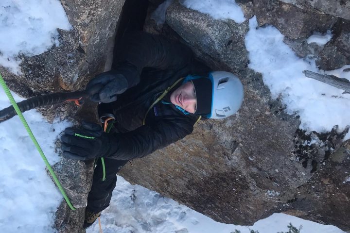 a person climbing up a snow covered slope