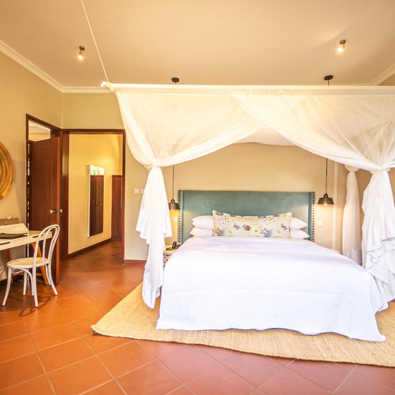 a bedroom with a bed and a chair in a room