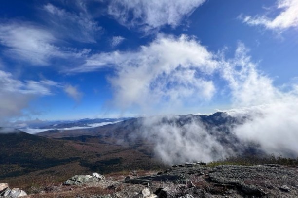 a group of clouds in the dirt with a mountain in the background